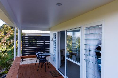 a balcony with a table and chairs on a house at Muri Ocean View Villas in Ngatangiia