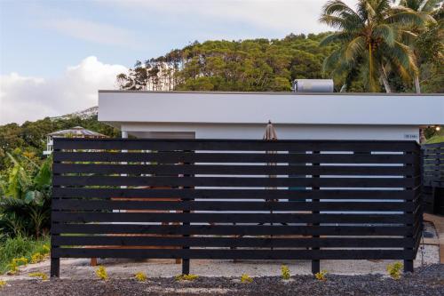 a black bench in front of a white building at Muri Ocean View Villas in Ngatangiia