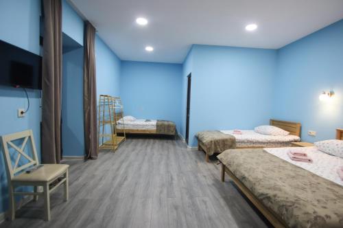 a room with three beds and a tv in it at Calm Home Apartment in Mestia