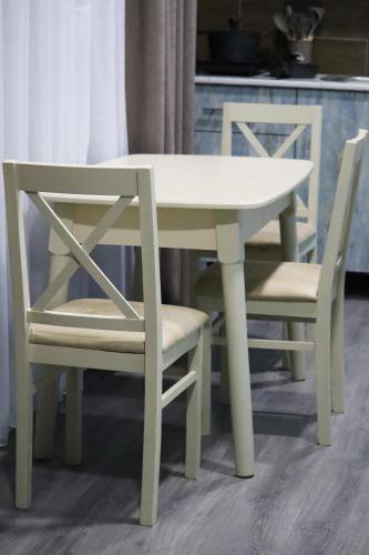 a white table and two chairs next to a kitchen at Calm Home Apartment in Mestia