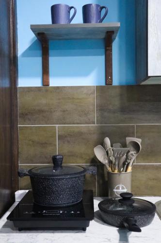 a stove top with a pot and plates and utensils at Calm Home Apartment in Mestia