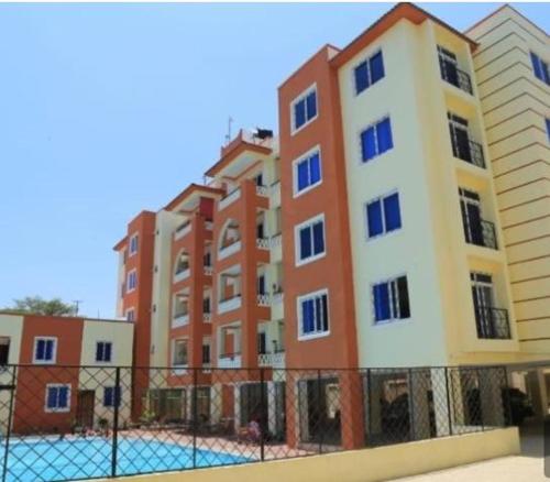 un edificio alto con una pista de tenis delante en Summer luxury apartments, en Mombasa