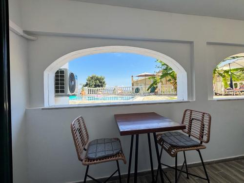 Una mesa y dos sillas en una habitación con ventana. en Kalami Bay Apartment, en Kalámi