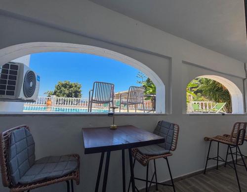 Una mesa y sillas en una habitación con ventana. en Kalami Bay Apartment, en Kalámi