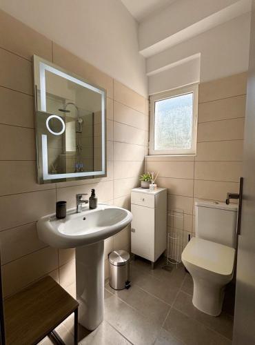 a bathroom with a sink and a toilet at Kalami Bay Apartment in Kalami