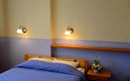a bedroom with a bed and two lights on the wall at Demians in Saldus