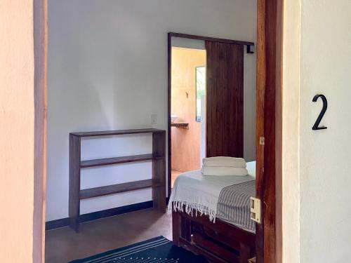 a bedroom with a small bed and a mirror at Maracuya Suites Zipolite in Zipolite