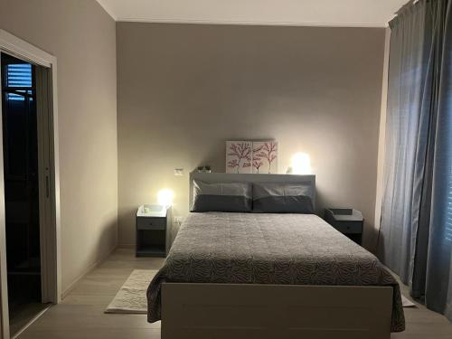 a bedroom with a large bed with two night stands at Maison Aielli 112 in San Giuseppe Vesuviano