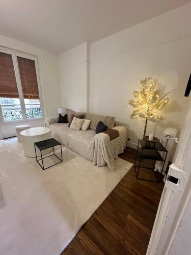 a living room with a couch and a table at Sublime appartement cosy près de la Tour Eiffel in Paris
