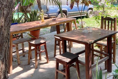 two wooden tables and chairs next to a tree at Maracuya Suites Zipolite in Zipolite
