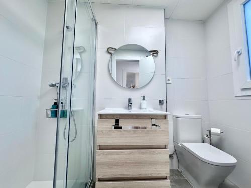 a bathroom with a toilet and a sink and a mirror at Playa Granada Apartamentos Moriscos II in Motril