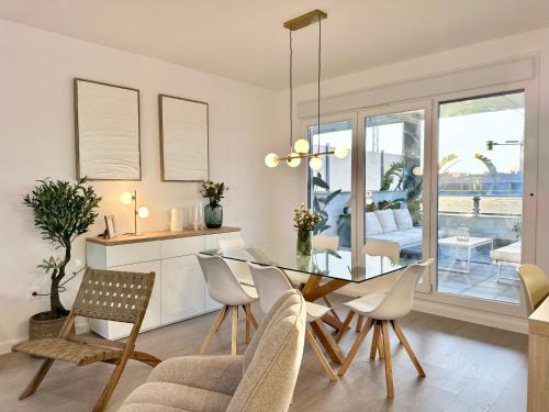 a kitchen and dining room with a glass table and chairs at Playa Granada Apartamentos Moriscos II in Motril