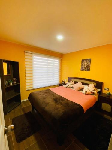 a bedroom with a large bed with yellow walls at Propiedades Buda-Tongoy-Chile in Tongoy