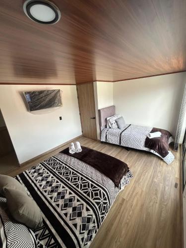 a room with two beds in a room at Hospedaje Balcones de Guatavita in Guatavita