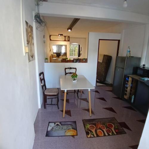 una pequeña cocina con una mesa blanca y una silla en Studio - Chantilla Vie, en Trou aux Biches