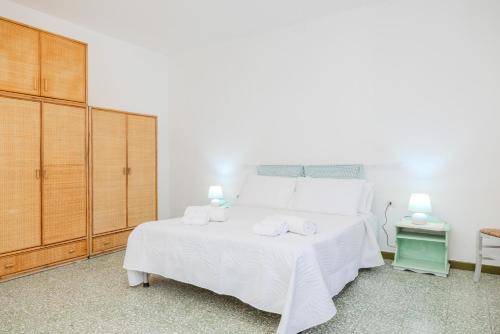 a bedroom with a white bed with towels on it at Arzachena centro 10 min from Costa Smeralda in Arzachena