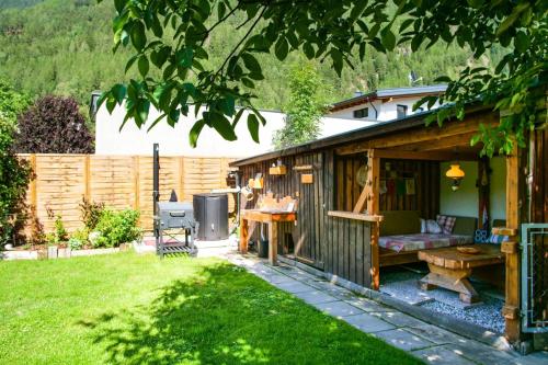 a wooden shed with a table and a bench in a yard at Sport Apartments Tirol in Umhausen
