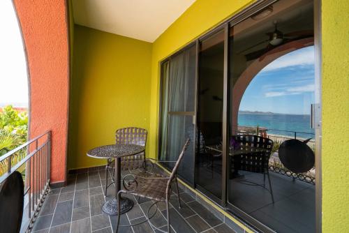 a balcony with a table and chairs and a view of the ocean at Hotel Palmas De Cortez in Los Barriles