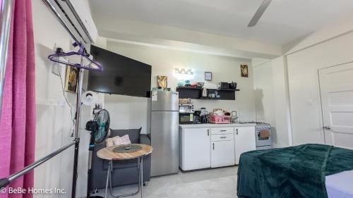a small kitchen with a table and a refrigerator at Aquoia Luxe Suite - 12min from UVF Airport in Vieux Fort