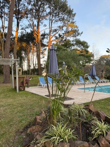 a patio with an umbrella and chairs and a pool at Neike Hotel Boutique in Punta del Este