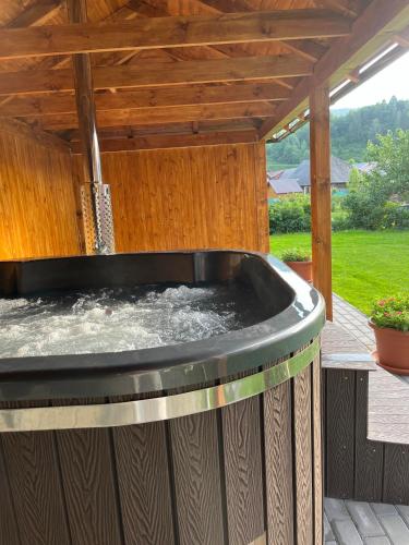 a hot tub on a deck with a pergola at Apartmánový dom Adriana in Zuberec