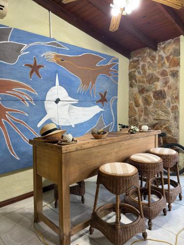 a table with stools in front of a mural at Neike Hotel Boutique in Punta del Este