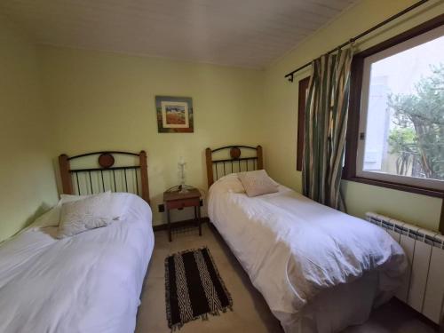 two beds in a room with a window at Neike Hotel Boutique in Punta del Este