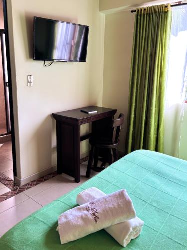a room with a desk and a bed with a towel at Hotel Villa Sofia in Nobsa
