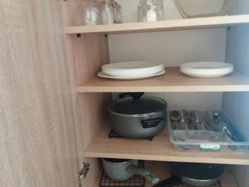 a cupboard with plates and bowls in it at Villa Mukhrovani in Mukhrovani