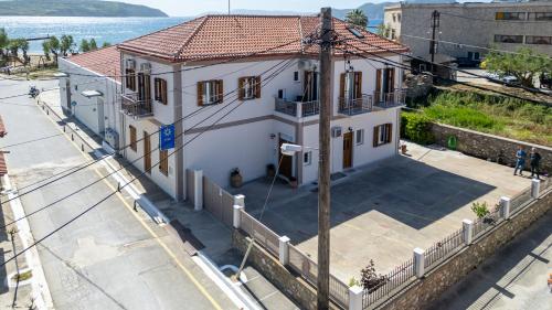 a white house with a red roof on a street at Mythos Suites-Apollo apartment in Methoni