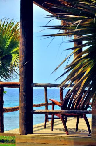 a wooden bench sitting on a porch overlooking the ocean at Cabarete Ecolodge Encuentro Surf Beach Kite in Perla Marina by BTCG Crypto in Bombita