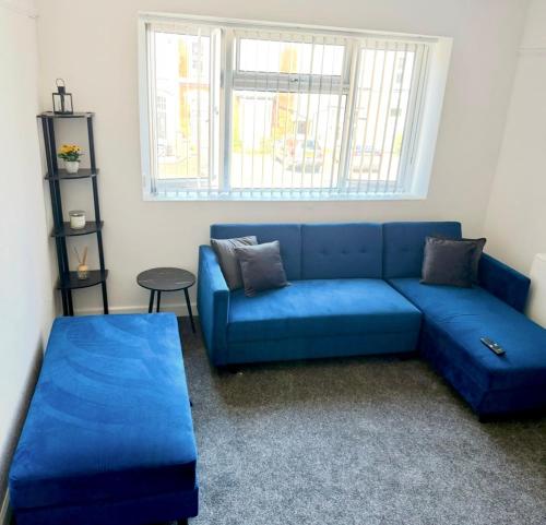 a blue couch in a living room with a window at Richmond Nights