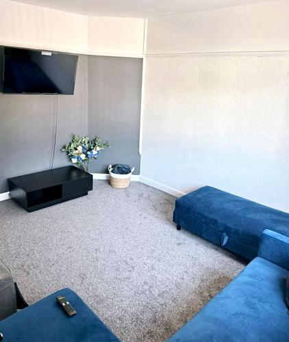 a living room with a blue couch and a tv at Richmond Nights