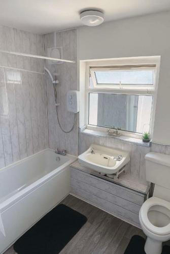 a bathroom with a tub and a sink and a toilet at Richmond Nights