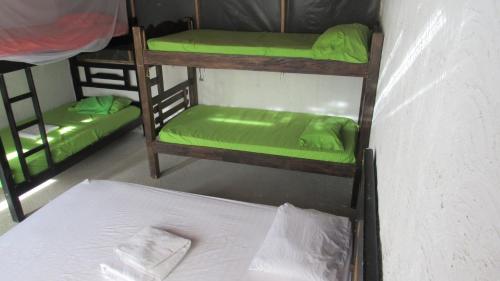 a room with three bunk beds and a bed at HOSTAL MIRADOR dentro del parque tayrona in El Zaino