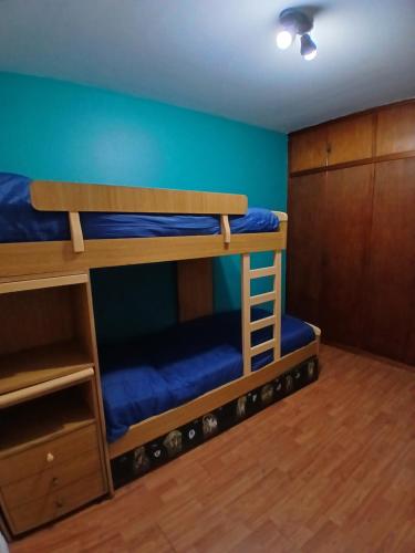 a bedroom with two bunk beds with blue walls at Un lugar cerca de todo in Buenos Aires