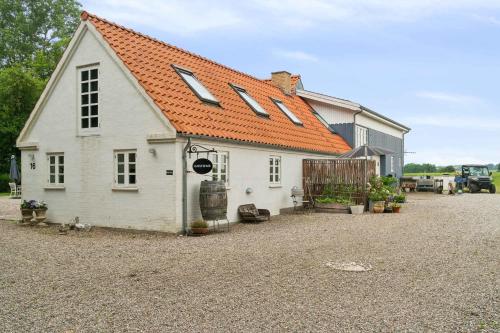 a small white house with an orange roof at Rural Charm And Beautiful Landscape in Svebølle