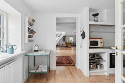 a kitchen with white walls and a blue table at Rural Charm And Beautiful Landscape in Svebølle