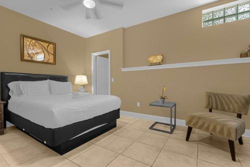 a bedroom with a large bed and a chair at 4BR Disney Family Townhouse Resort in Orlando - with Resort Pool, Gym, Games, & Jacuzzi in Orlando