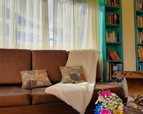 a brown couch with pillows in a living room at Hotel Villa Sofia in Nobsa