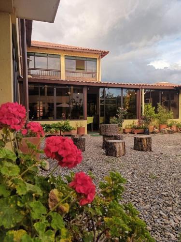 a building with red flowers in front of it at Hotel Villa Sofia in Nobsa