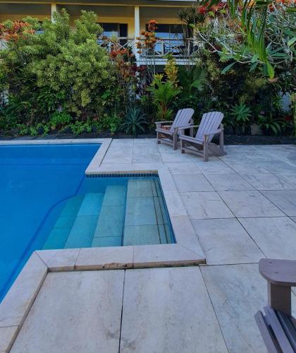 two chairs sitting next to a swimming pool at Vaea Hotel Samoa in Apia