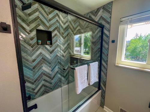 a bathroom with a glass shower with a stone wall at One Blue Rose in Colorado Springs