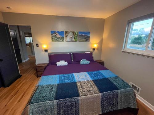 a bedroom with a large bed with two towels on it at One Blue Rose in Colorado Springs