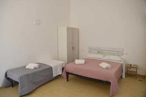 two beds in a white room with pink sheets at MEITHRAS holiday homes in Agrigento