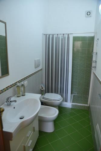 a bathroom with a toilet and a sink and a shower at MEITHRAS holiday homes in Agrigento