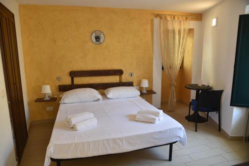 a bedroom with a bed with two towels on it at MEITHRAS holiday homes in Agrigento
