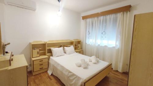 una camera da letto con un letto bianco e una finestra di A&B Apartments - Banrezes a Macedo de Cavaleiros