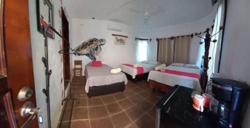 a hotel room with two beds and a television at Hotel Quinto Sol in Mazunte