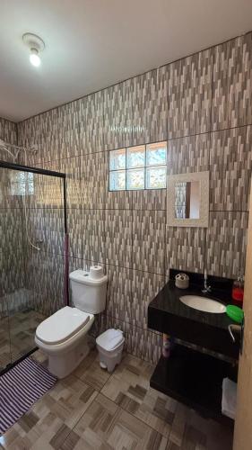 a bathroom with a toilet and a sink and a shower at Recanto da Paz - Monte Verde in Monte Verde